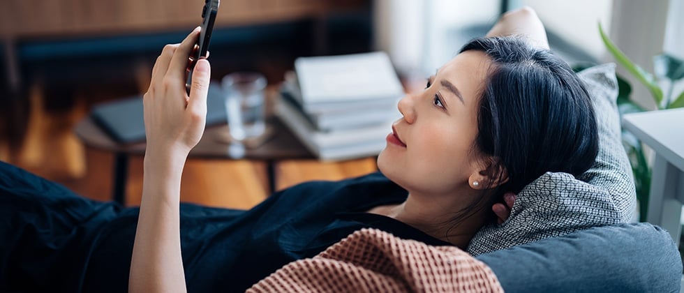 Woman using a dating app at home